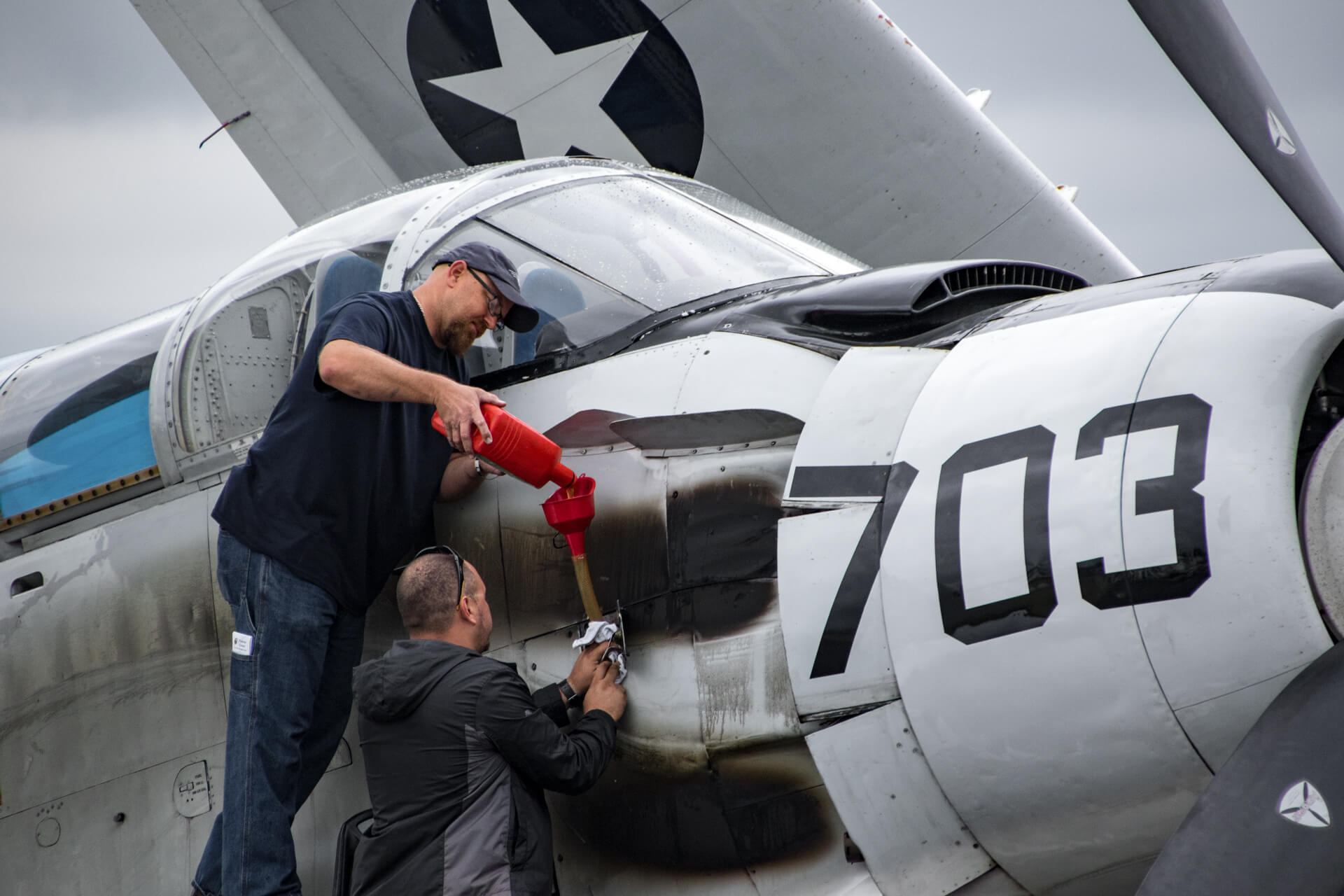 Topping off the oil of a Douglas EA-1E Skyraider.